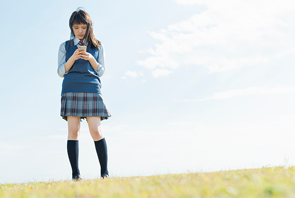 スマートフォンを使う女子高生