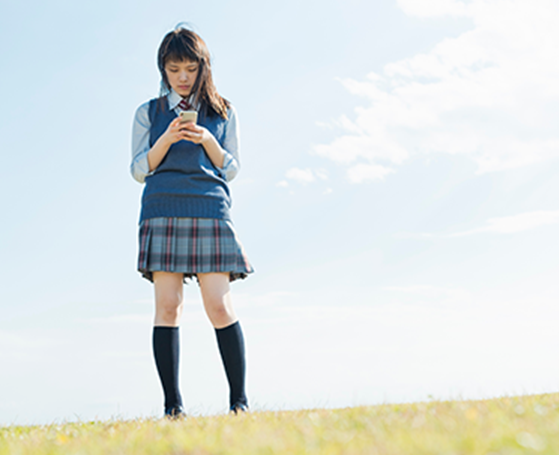 スマートフォンを使う女子高生